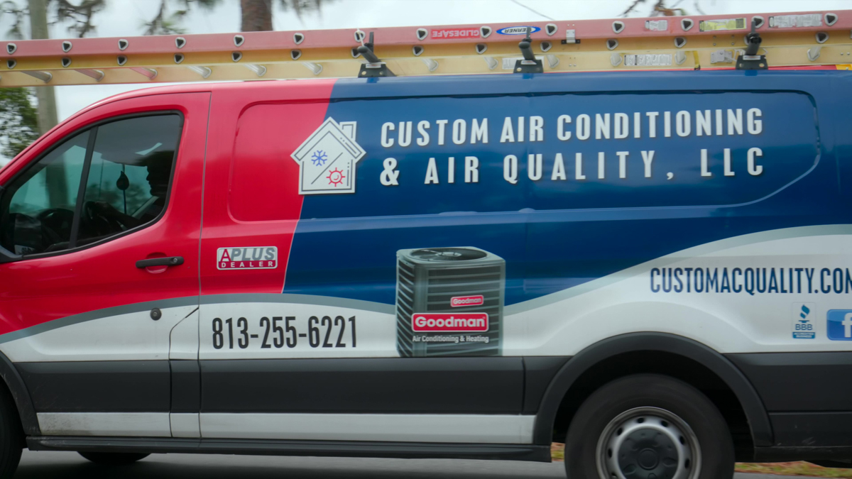Ductless HVAC 2 Custom air conditioning and air quality service truck driving through a residential neighborhood