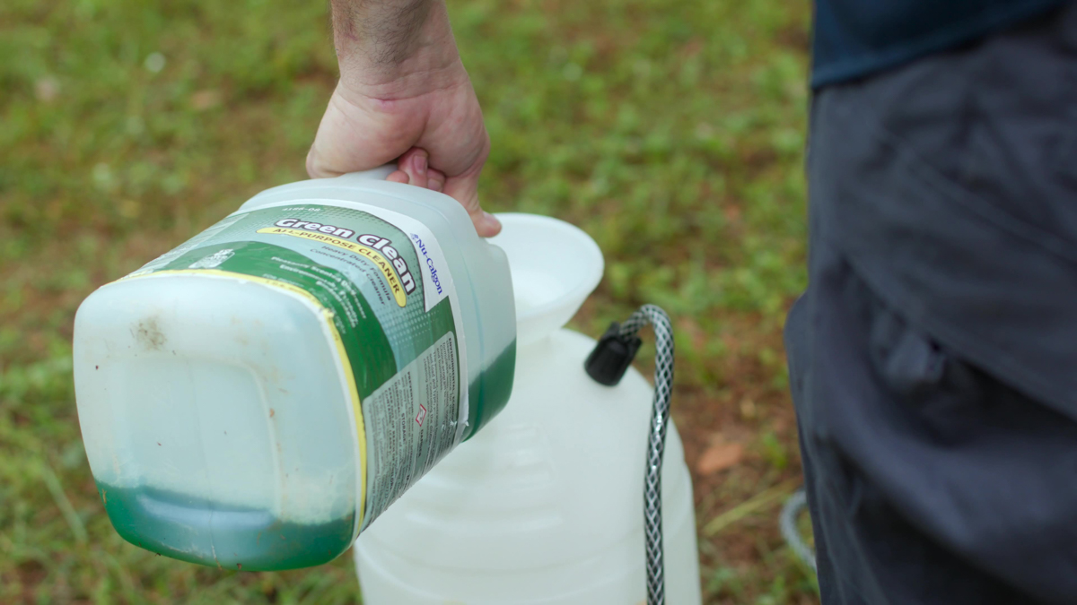 Custom air conditioning and air quality technician handling refrigerant during maintenance