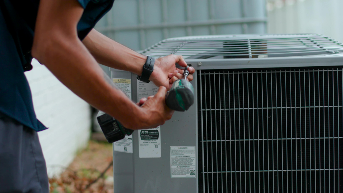 Custom air conditioning and air quality technician inspecting an HVAC unit for potential issues