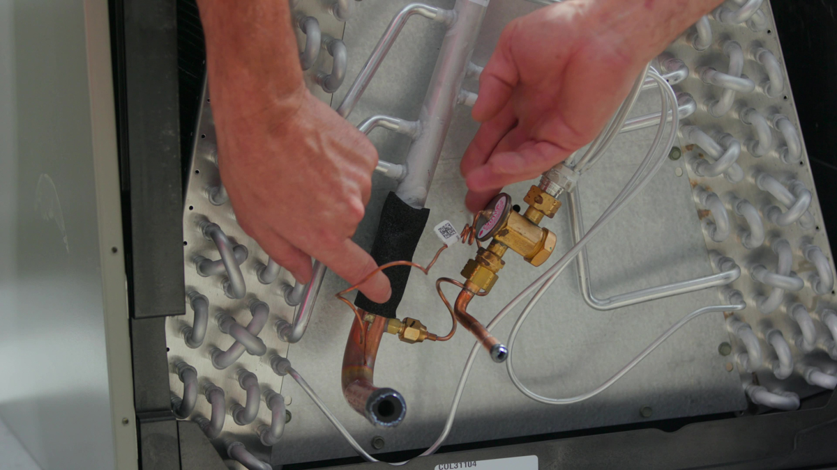 Custom air conditioning and air quality technician performing diagnostics to ensure system efficiency 1