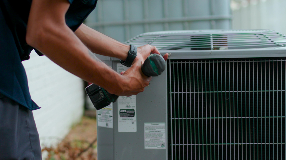 Custom air conditioning and air quality technician performing routine maintenance on an HVAC system 1