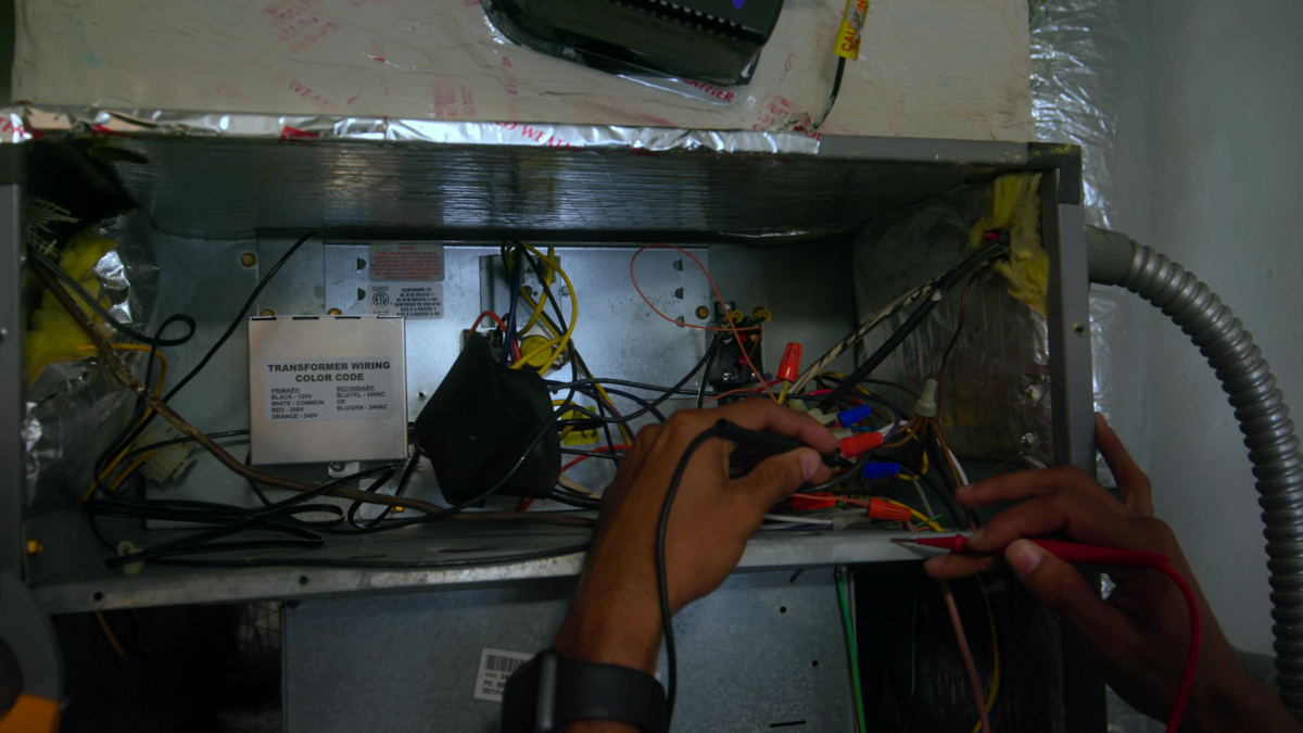 Custom air conditioning and air quality technician working on an HVAC unit