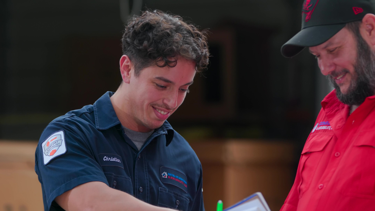 Team of custom air conditioning and air quality technicians discussing refrigerant management strategies